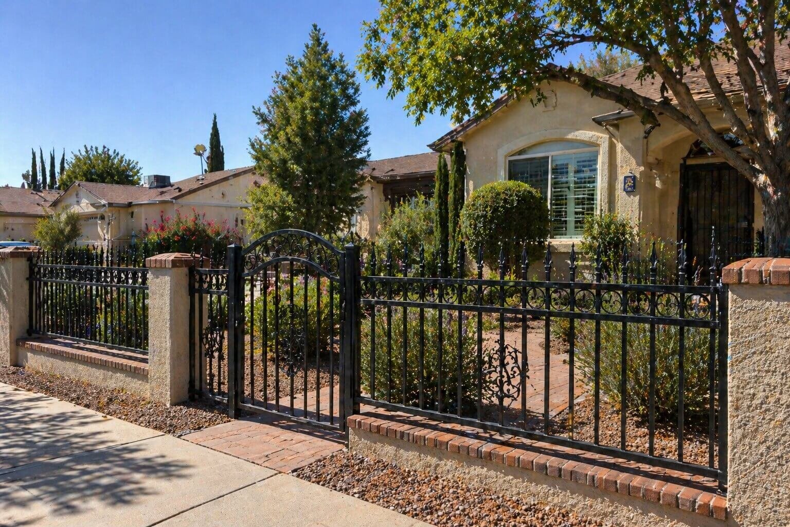 Wrought iron fence installation in El Paso TX residential neighborhood with decorative metal gate